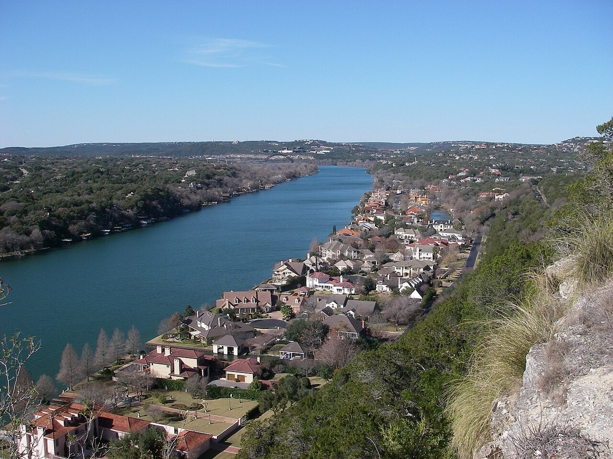 A couple watching the sunset over Lake Austin from the stone overlook at Mount Bonnell
