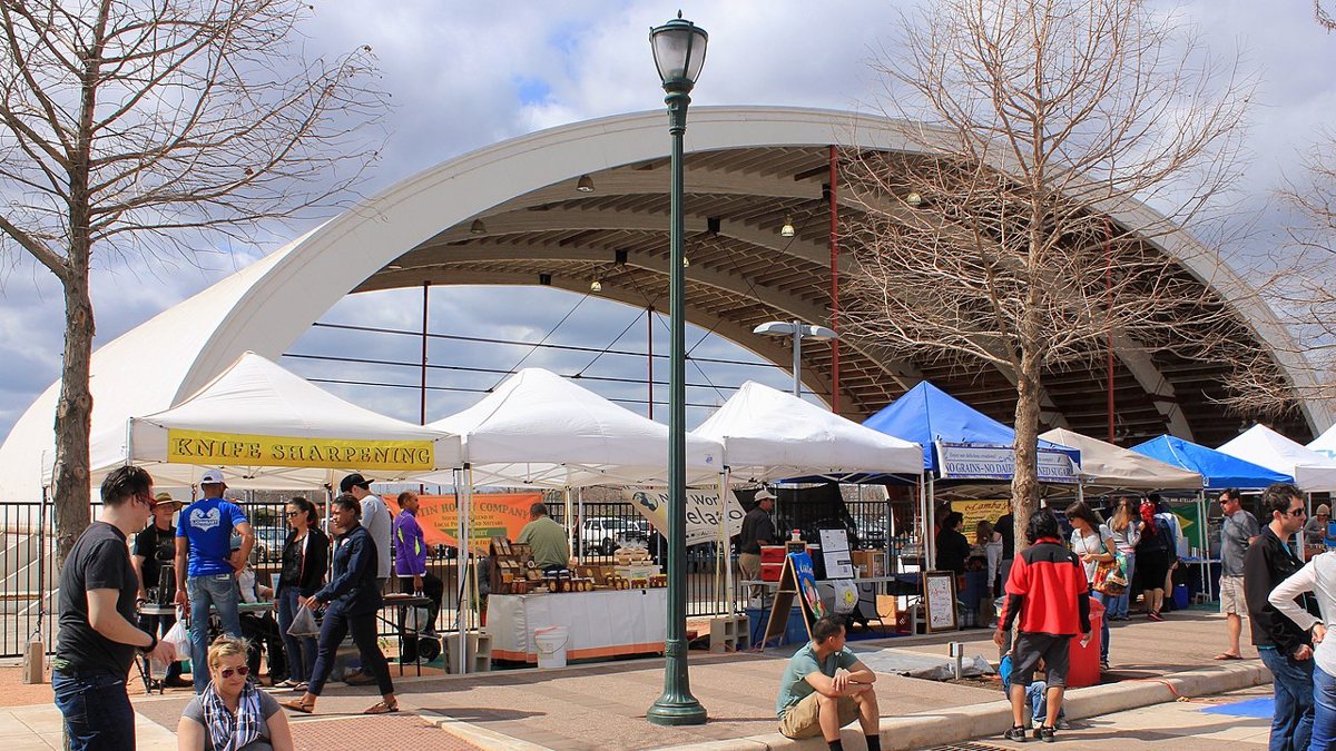 outdoor farmers market at Mueller neighborhood park in Austin Texas on a Sunday morning with vendor tents and shoppers