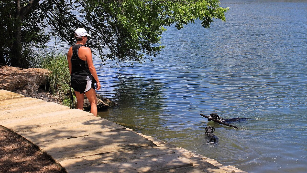 morning joggers on the Lady Bird Lake hike and bike trail with downtown Austin skyline in background